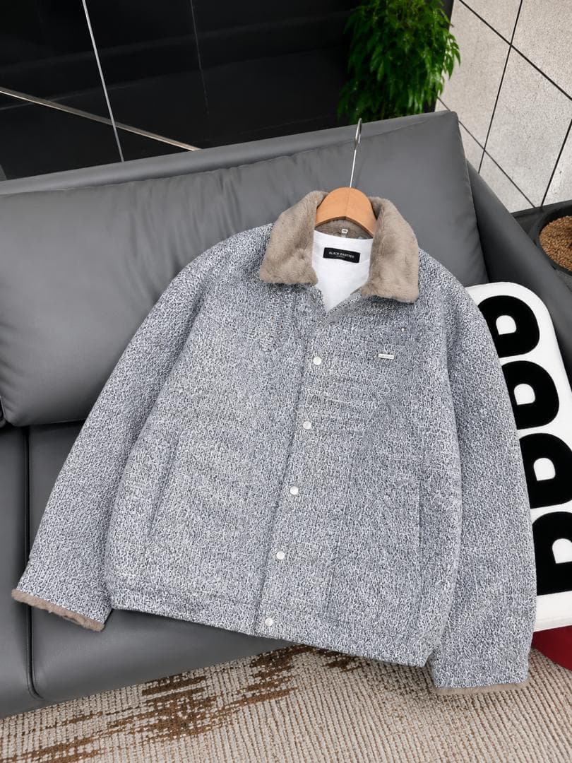 Grey bouclé jacket with beige faux fur collar and cuffs over a white t-shirt on a hanger.