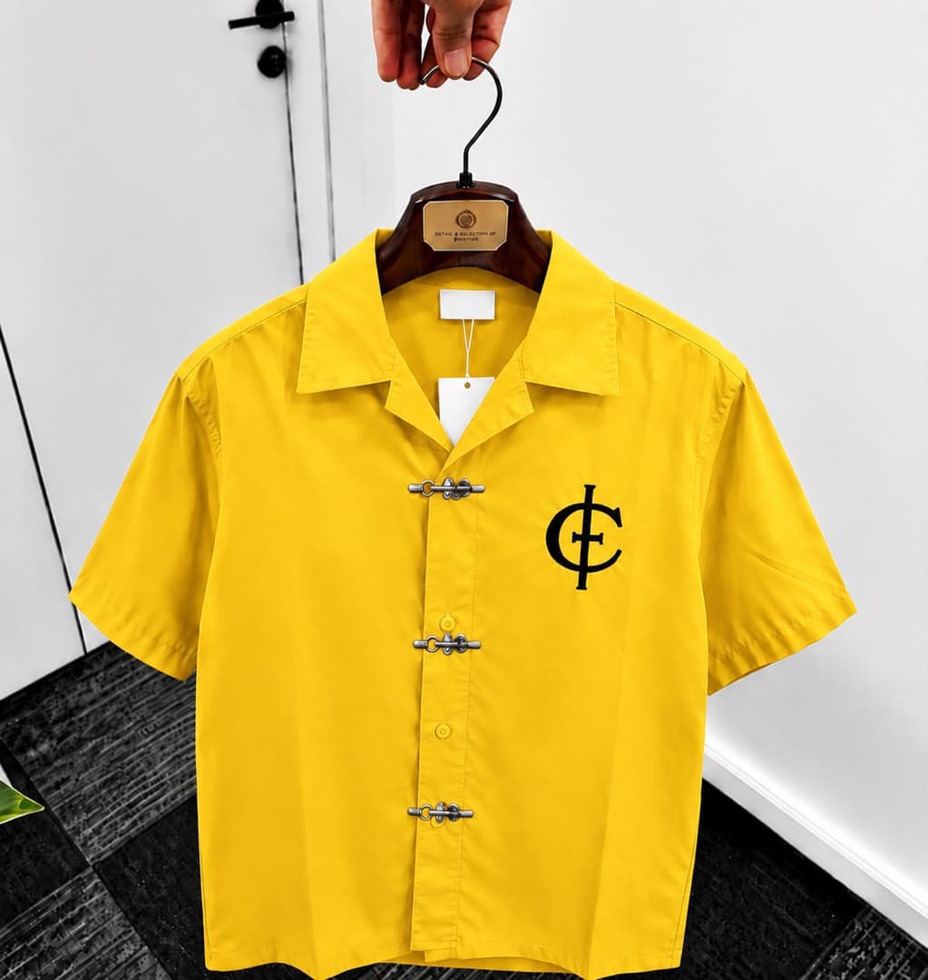 Yellow unisex short sleeve shirt with toggle buttons and black chest logo.