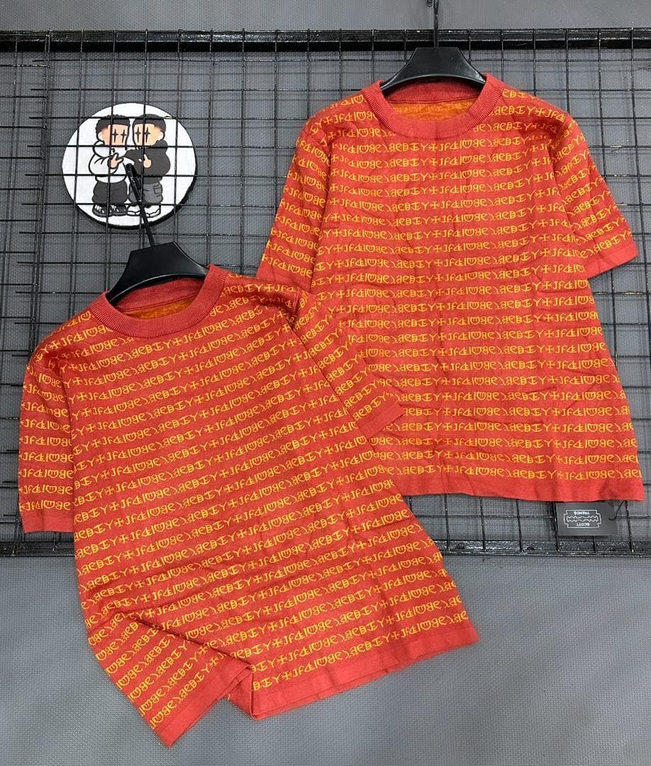 Red two-piece set with all-over repeating text print on short sleeve top and shorts.