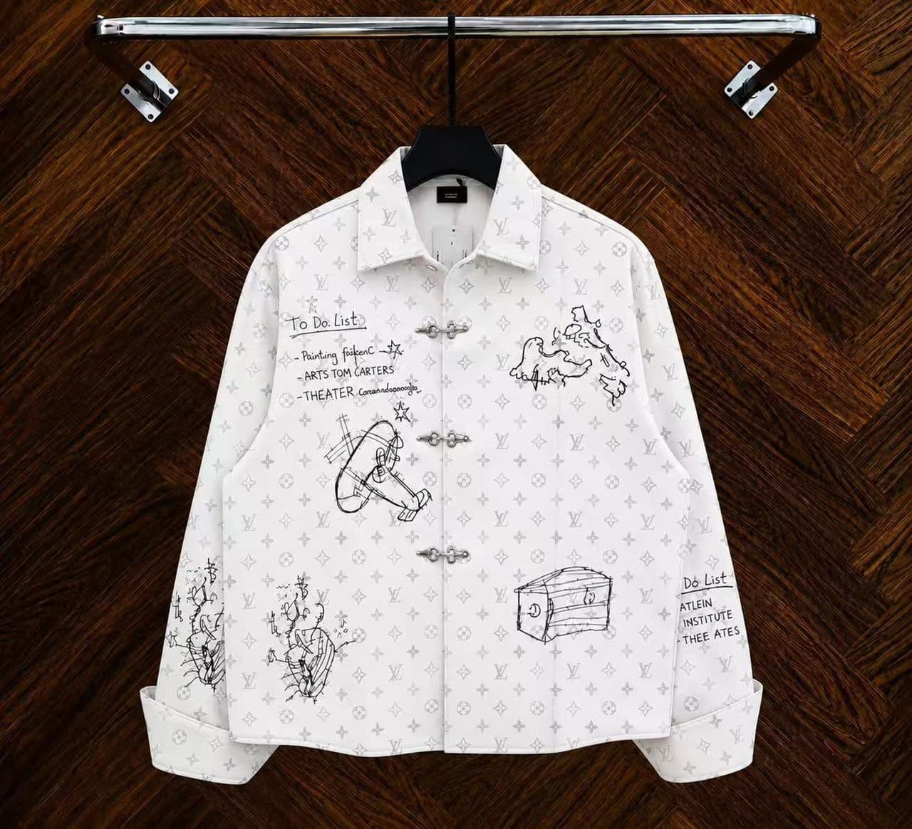 White monogram sketch toggle jacket hanging on rack with white drawings.