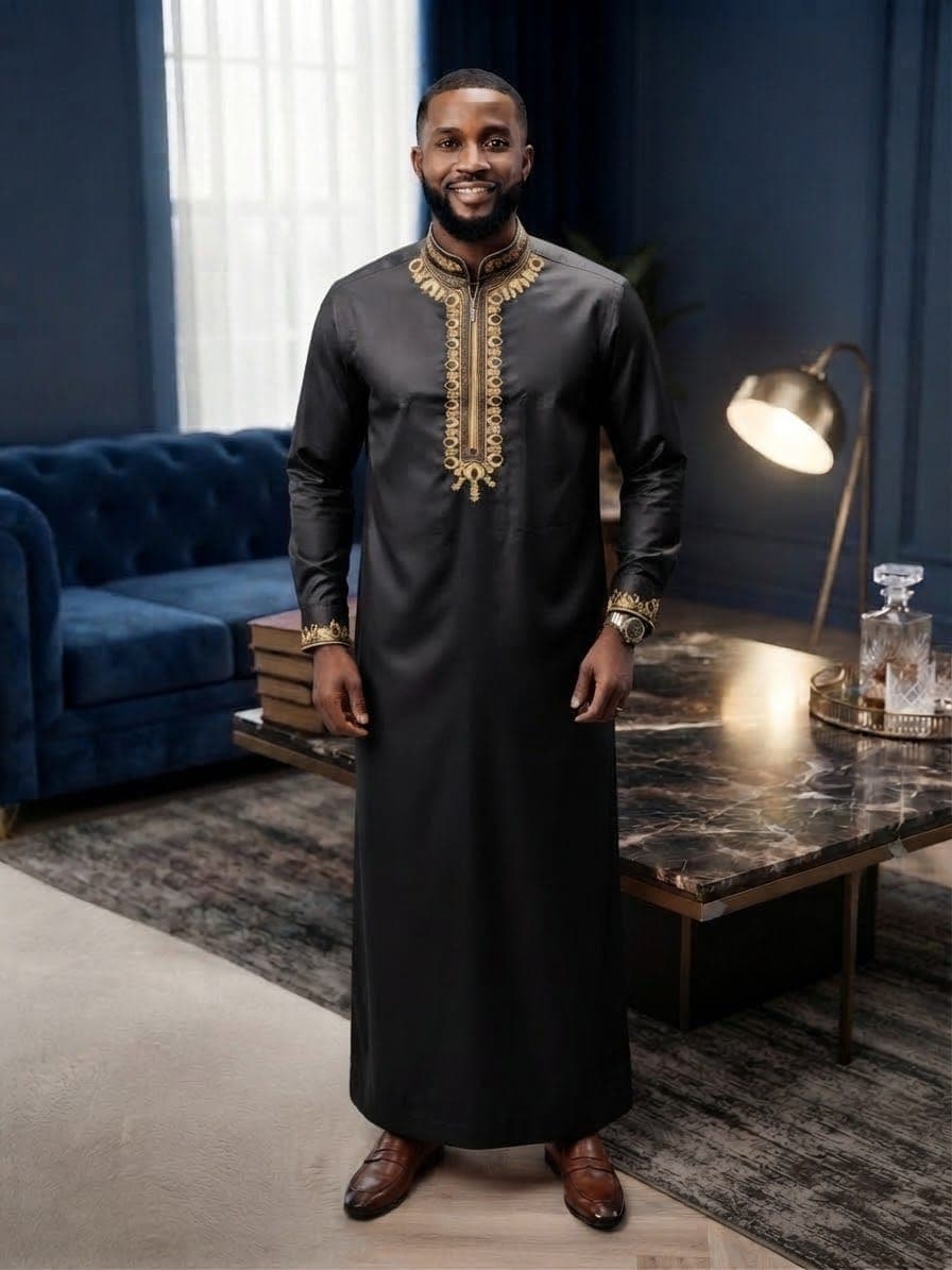 Model wearing black embroidered kaftan with intricate gold embroidery.