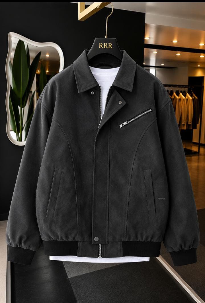 Black suede bomber jacket with diagonal zip pocket in showroom on hanger.