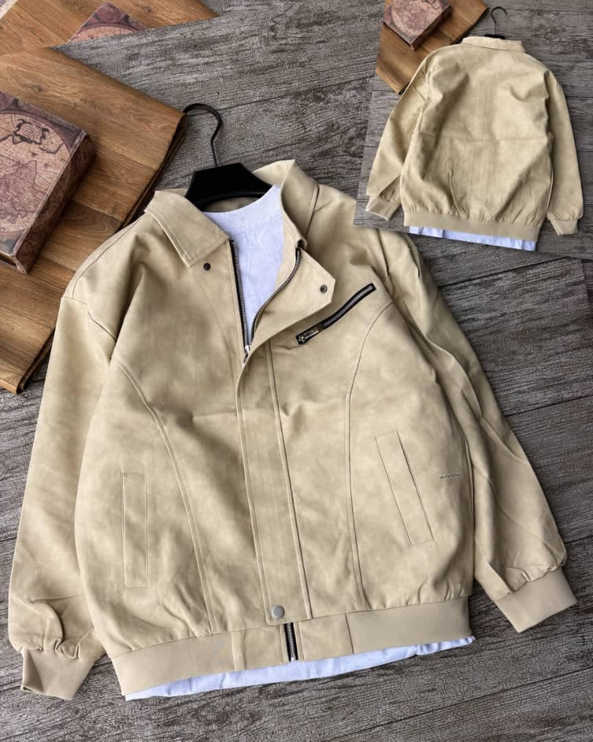 Beige suede bomber jacket with chest zip on wooden surface, back view shown.