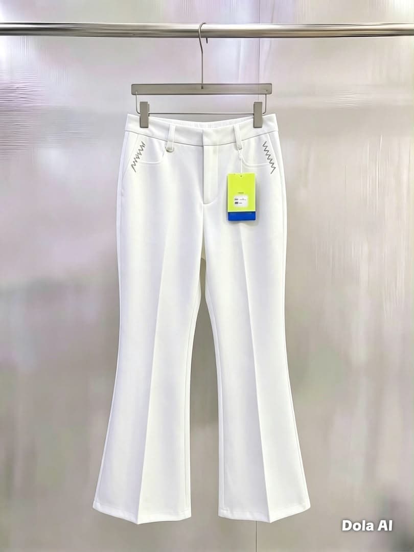 White flare trousers with white zigzag pocket embroidery, hanging view.