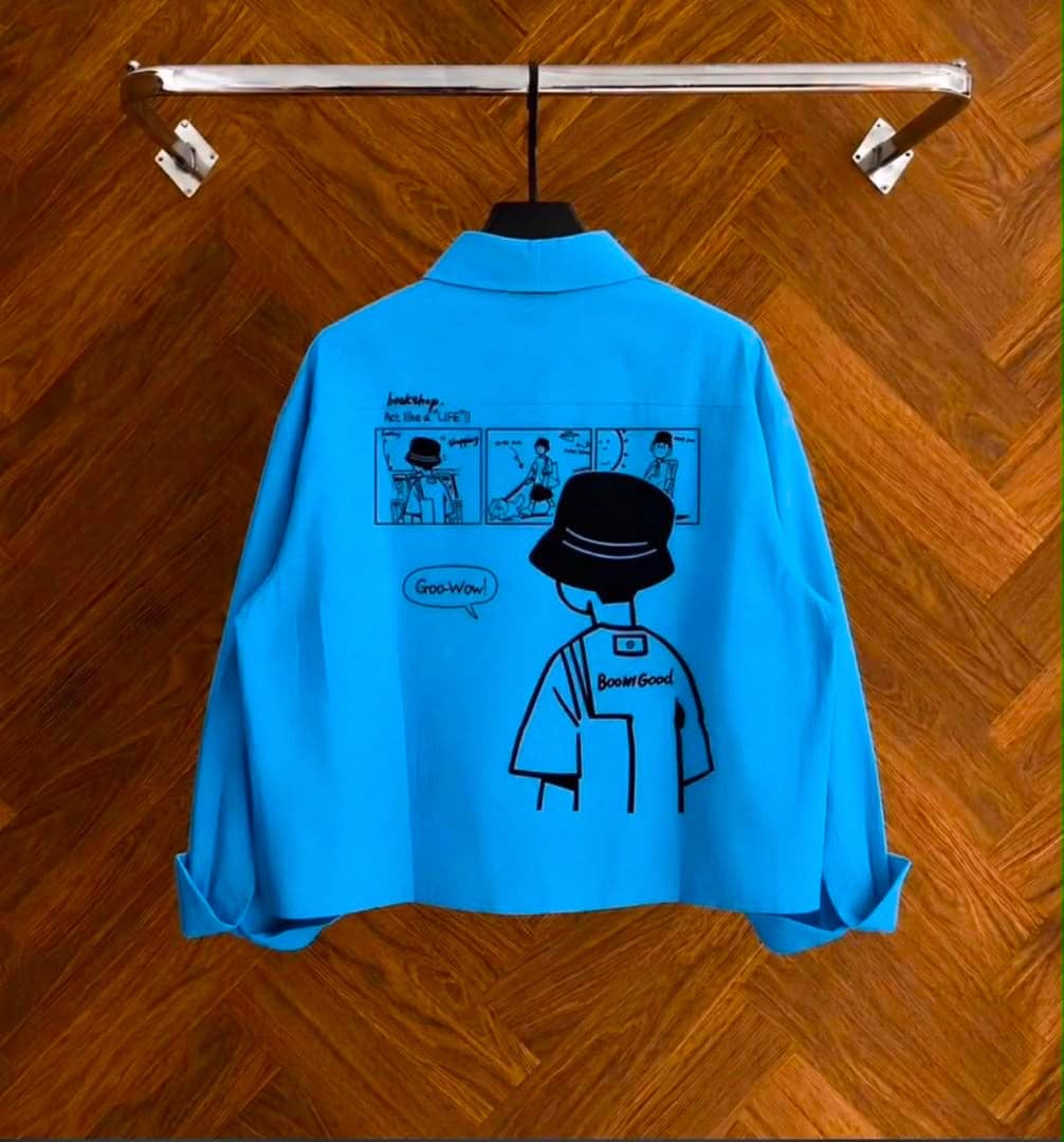 Back view of blue cropped shirt displaying comic graphic print and text.