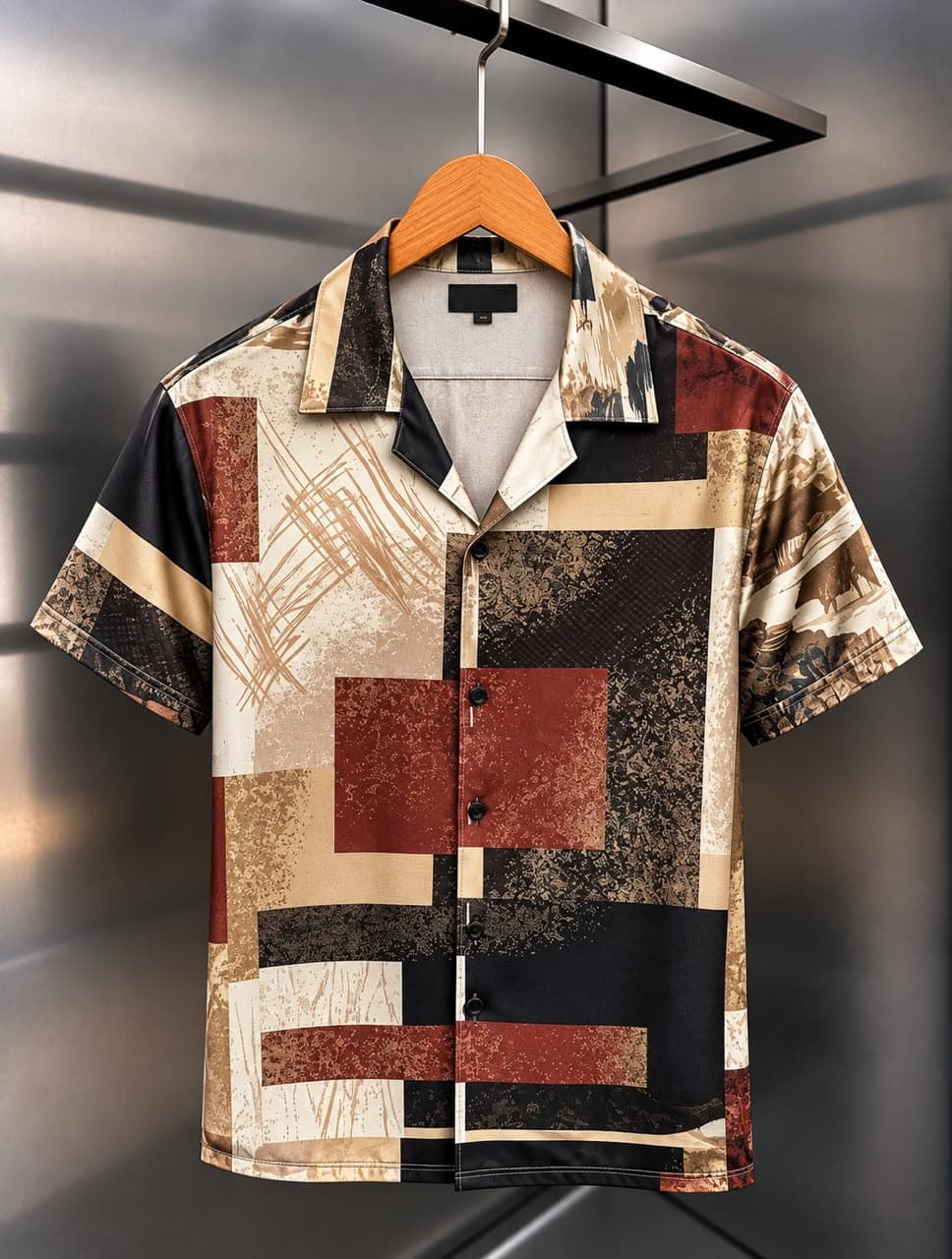 Front view of short-sleeved satin shirt with black, white, and gold mountain landscape print.
