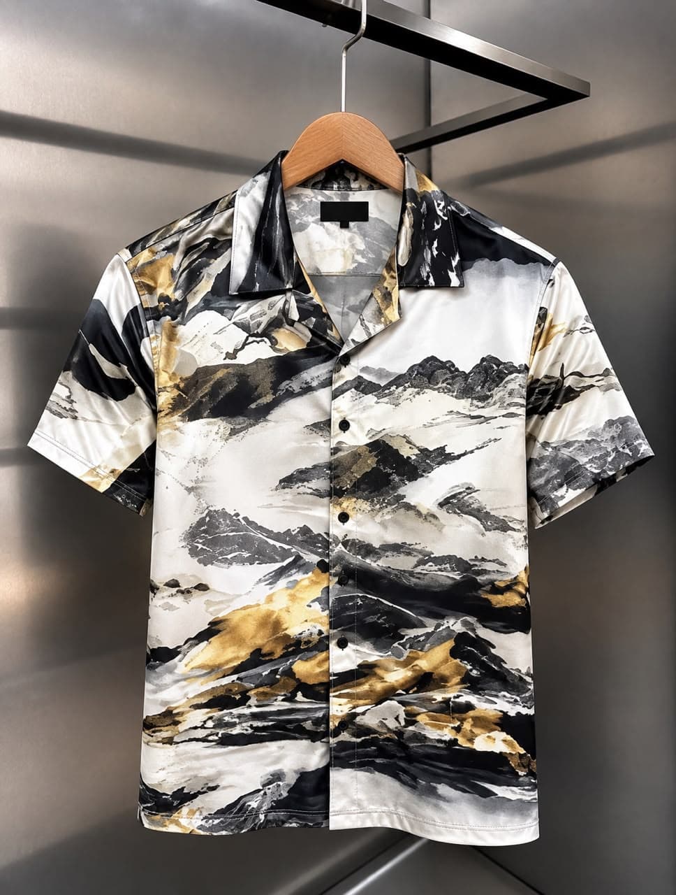 Front view of short-sleeved satin shirt with geometric abstract print in beige, black, red, and brown.
