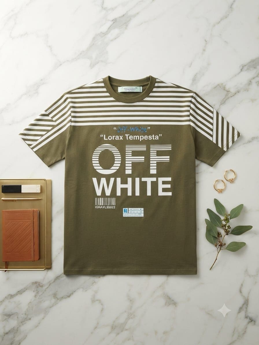 Green H&M Man graphic t-shirt on wooden table with watch, sunglasses and notebook.