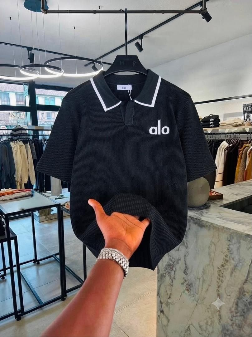 Black Alo ribbed polo shirt with white collar trim.