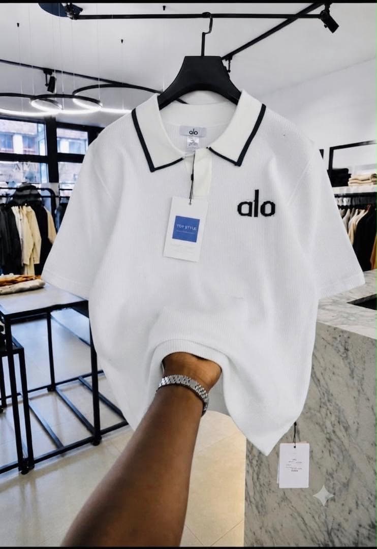 White Alo ribbed polo shirt with black collar trim.