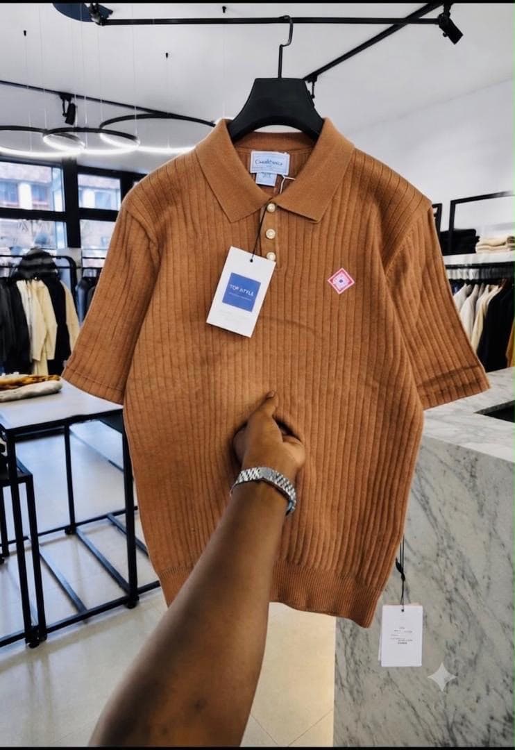 Brown ribbed polo shirt with diamond logo on chest.
