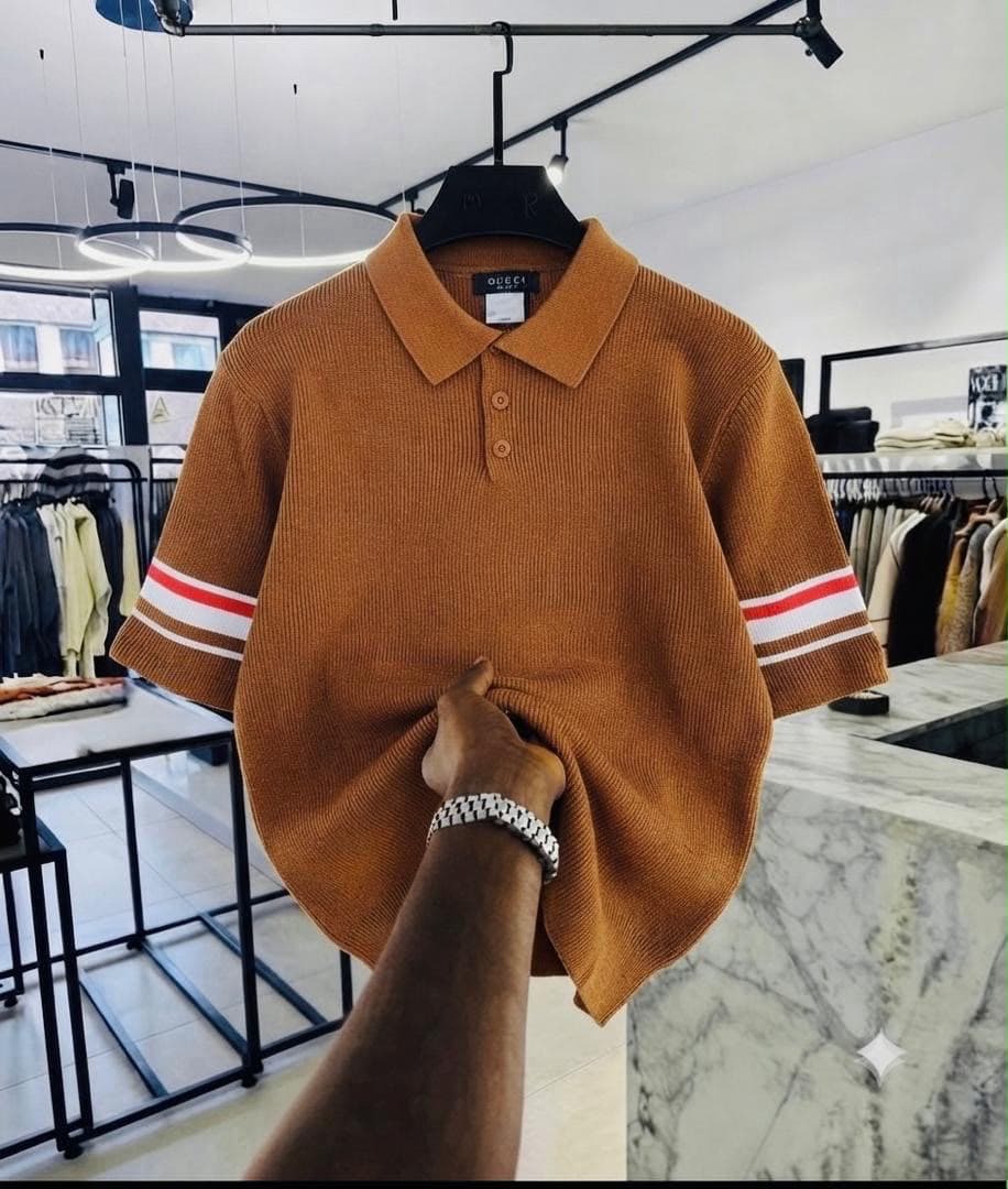Brown ribbed polo shirt with red and white striped sleeves.