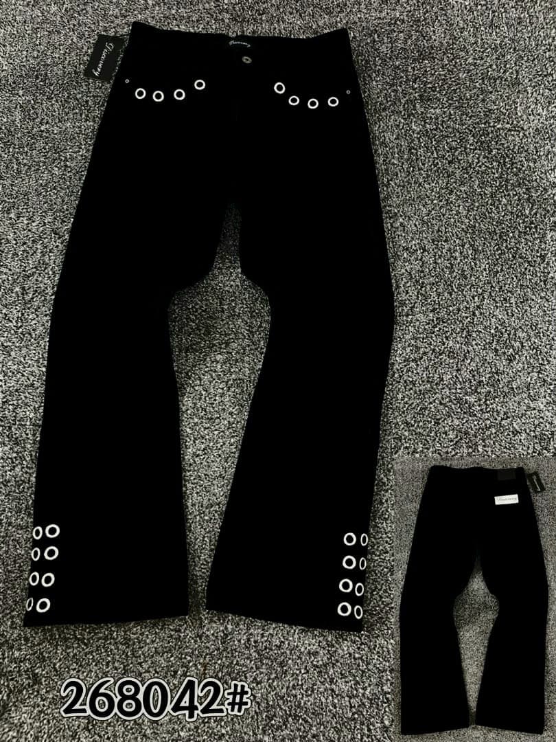 Black baggy jeans with white eyelets on waistband and leg hems displayed flat on gray carpet.