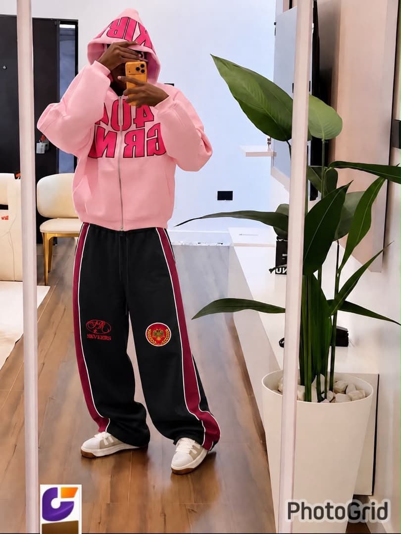 Model wearing black side-stripe joggers with SEVEERS embroidery and pink hoodie.