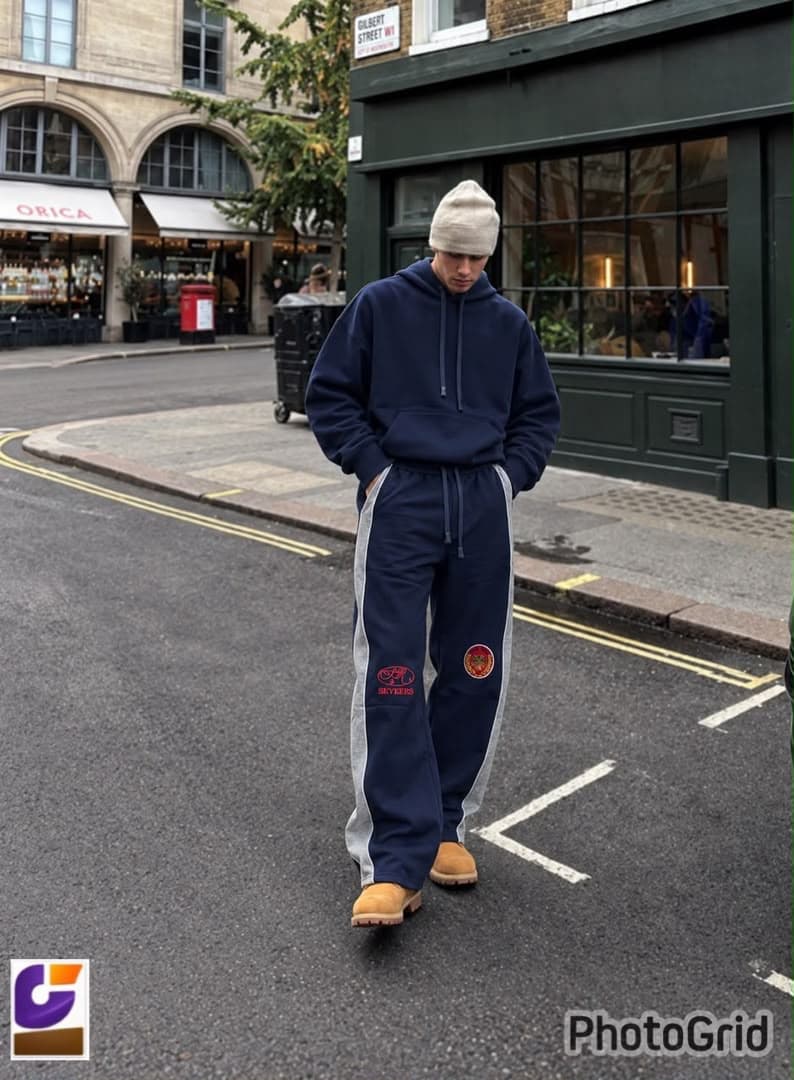 Model wearing navy side-stripe joggers with SEVEERS embroidery on city street.