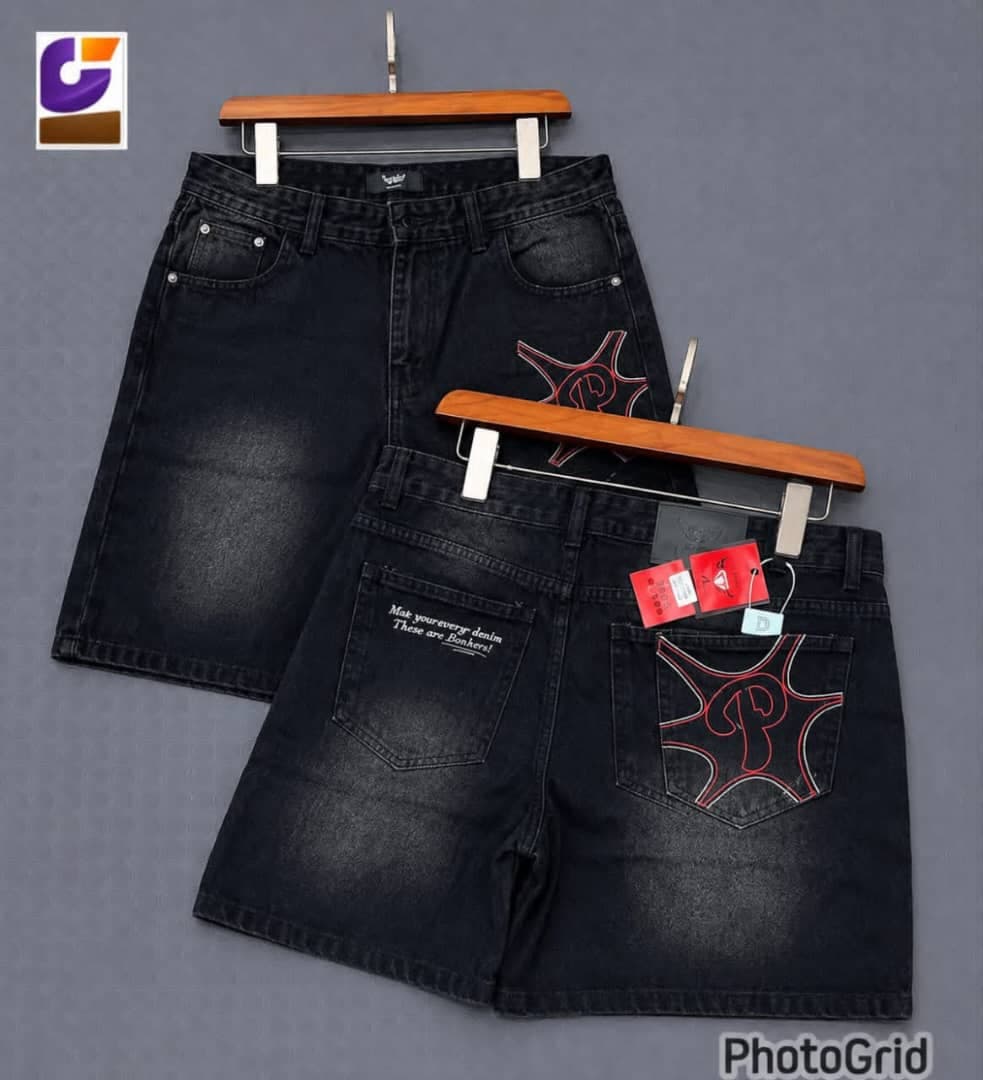 Light blue denim shorts with black tribal prints and AMIRI tag.