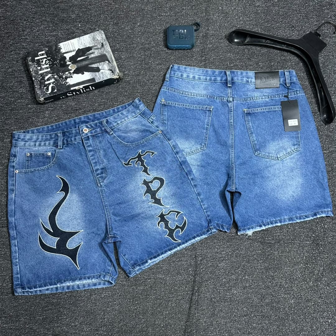 Light blue denim shorts with red star embroidery and text on pocket.