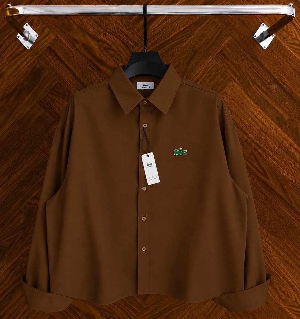 Brown Lacoste long sleeve button-down shirt with chest croc embroidery on black hanger.