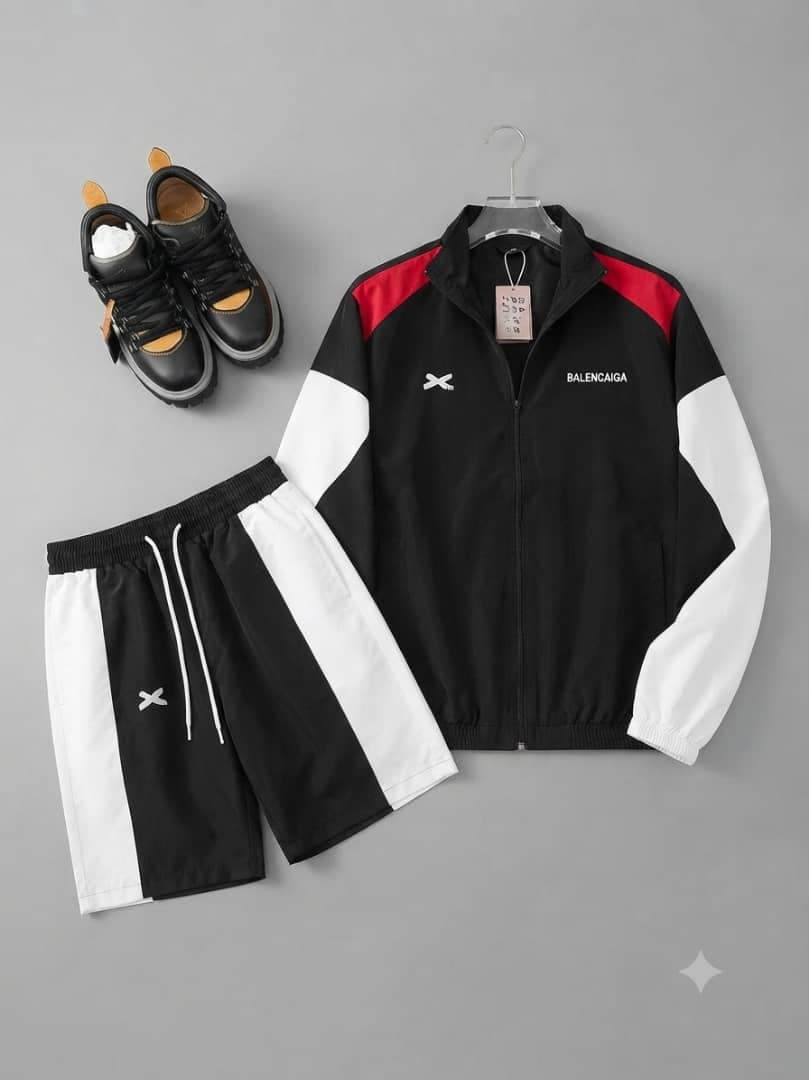 Balenciaga black colorblock tracksuit set with zip jacket, shorts, and styling sneakers in flat lay.