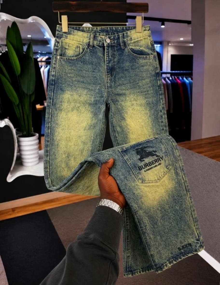 Model seated wearing black baggy jeans with metal clasp accents, white top and sneakers, with inset product views.
