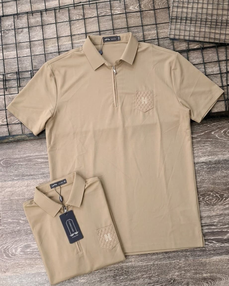 Beige short sleeve quarter-zip polo shirt on hanger and folded, showing quilted H pocket and tag.