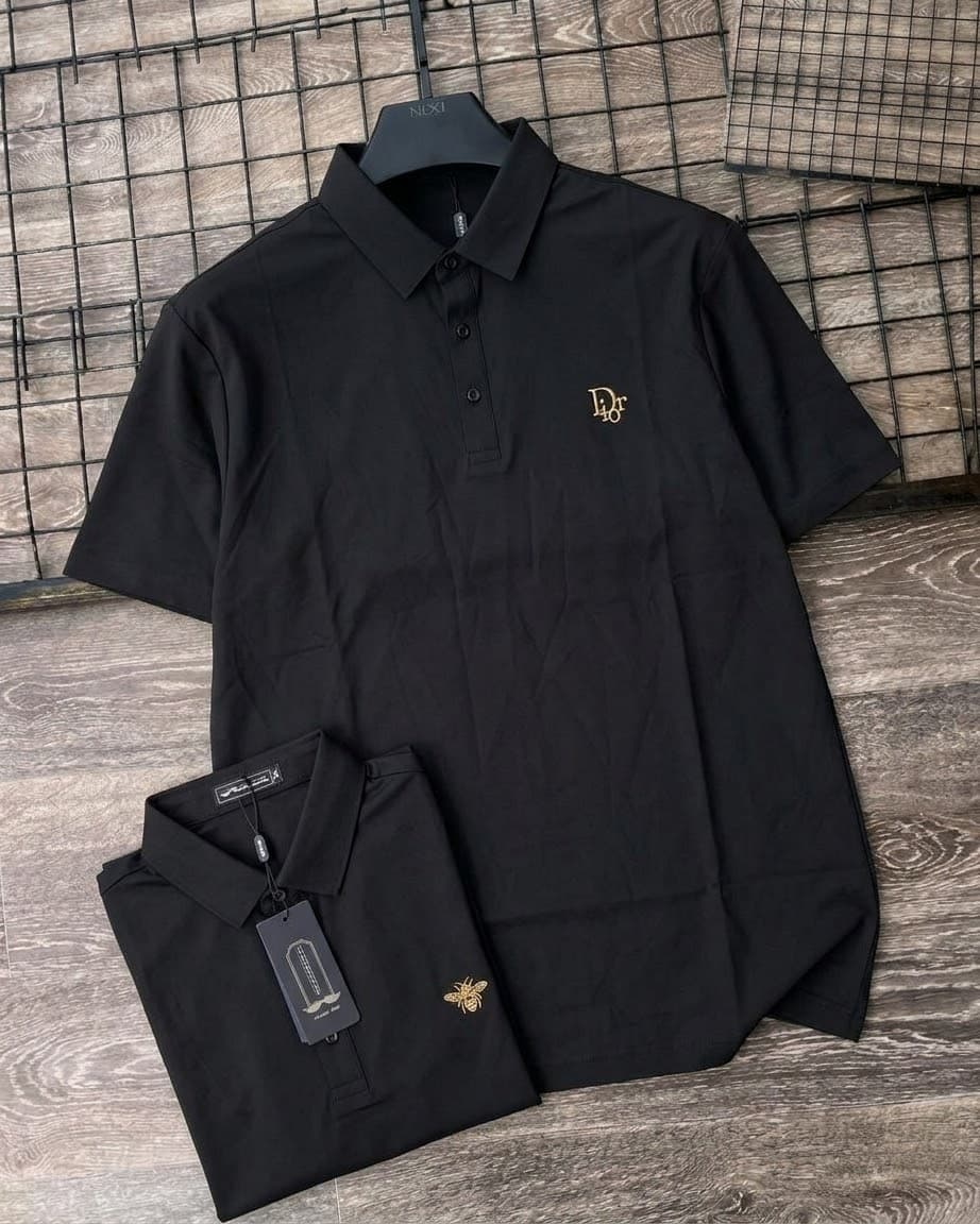 Black short sleeve polo shirt on hanger and folded, displaying Dior logo, bee embroidery and tags.