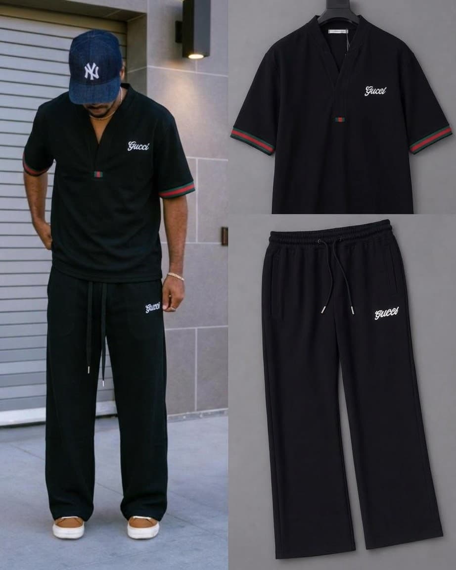 Flat lay of black Gucci two-piece set including short sleeve top, drawstring pants and white sneakers on gray background.