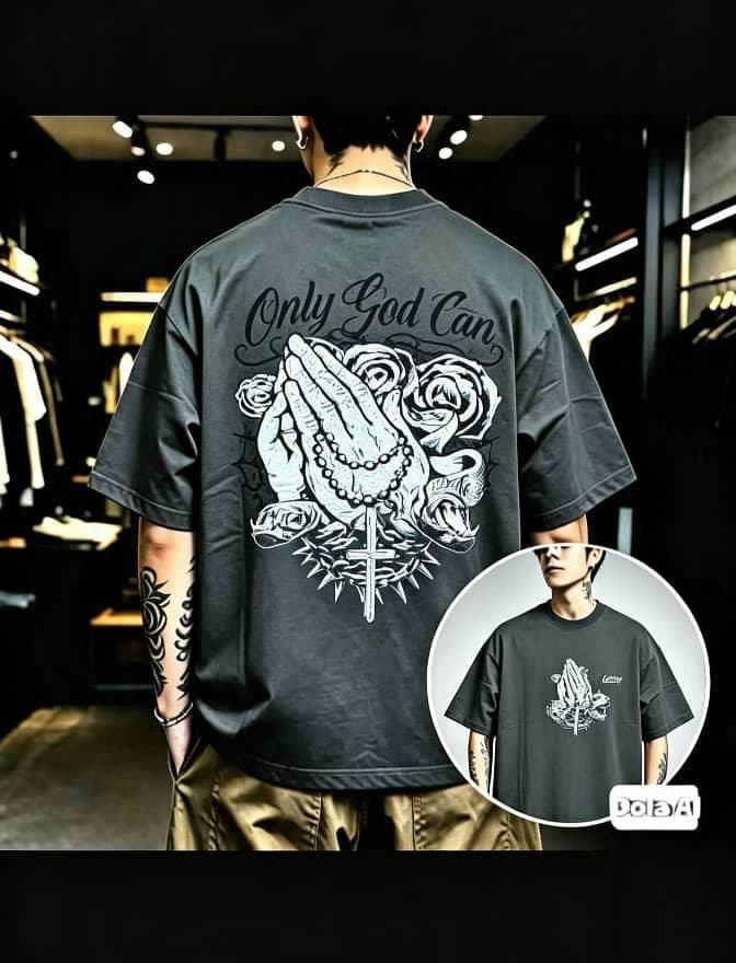 Man in dark gray oversized T-shirt with Only God Can praying hands roses and cross graphic on back and front inset.