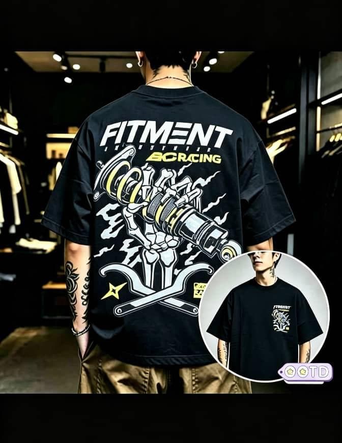 Man in black oversized T-shirt with large Fitment 80 Racing skeleton mechanical graphic on back and front inset.