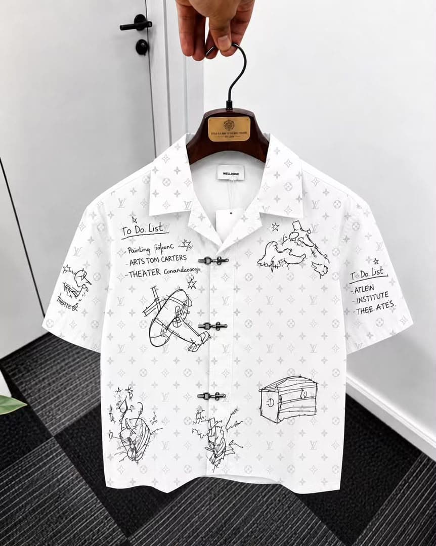 White monogram sketch print short sleeve shirt on hanger.