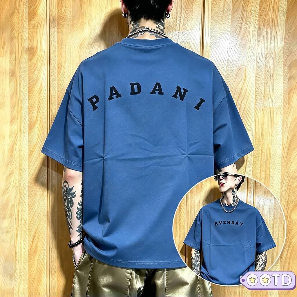 Model in black PADANI oversized t-shirt, back view showing arched white text.