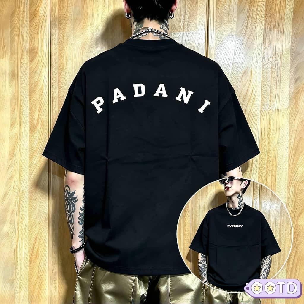 Model in blue PADANI oversized t-shirt, back view with black arched lettering.