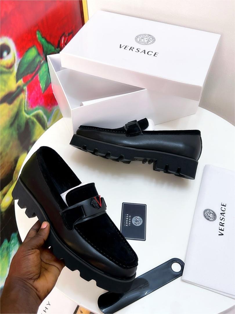 Black Versace loafer with chunky lug sole, Medusa emblem and white Versace box on display.