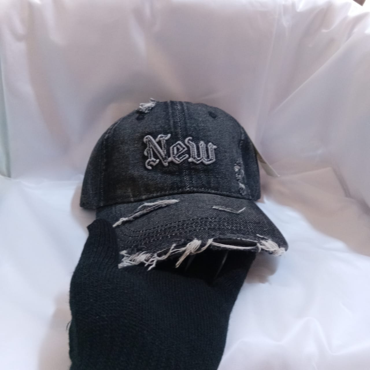 Black distressed cap with New gothic embroidery and frayed brim.