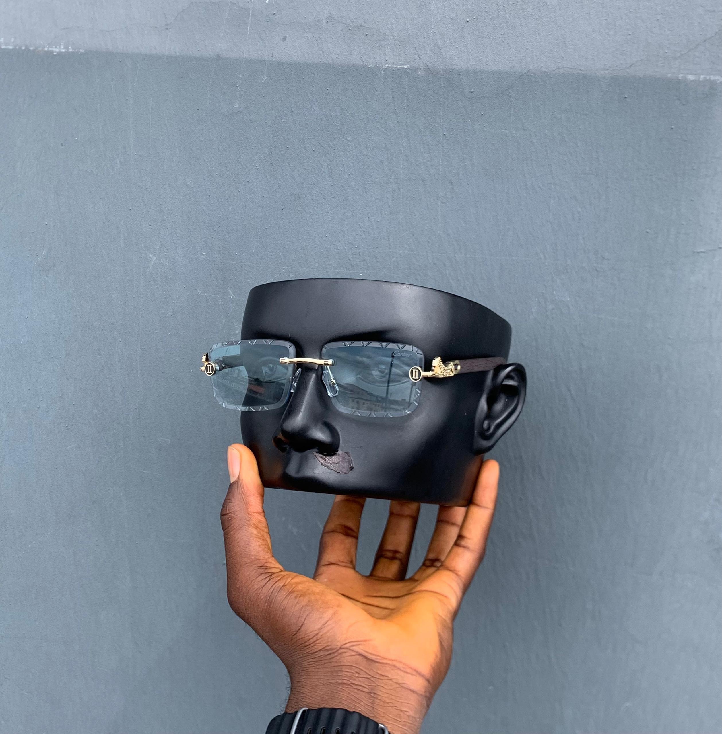 Cartier square rimless sunglasses with blue lenses on black mannequin head.