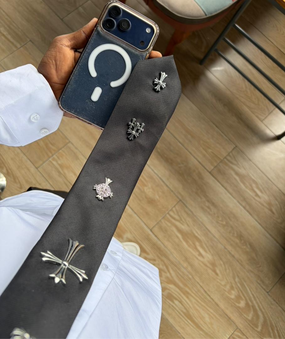 Black chrome customized tie with multiple silver cross designs including one with pink stones.