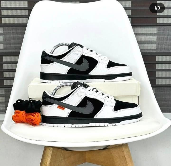 Black and white Off-White x Nike Dunk Low sneakers on white chair with shoebox and extra laces