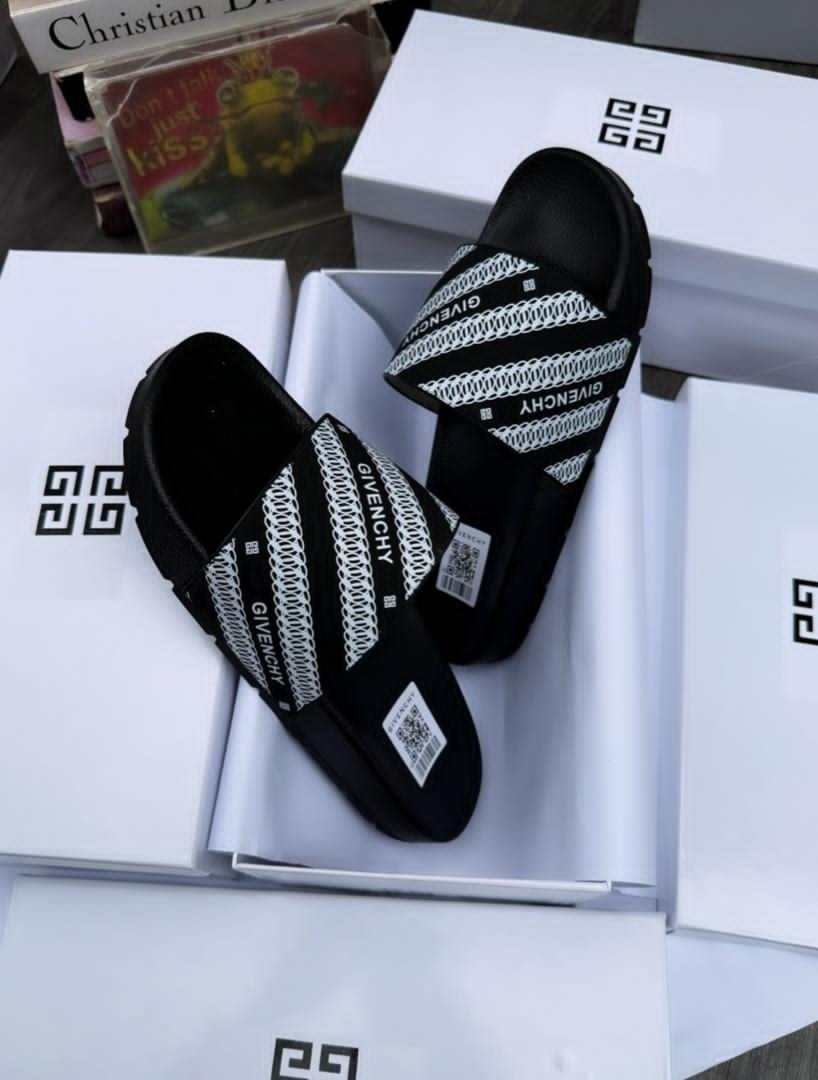 Pair of black Givenchy slides with white logo pattern in white branded boxes.