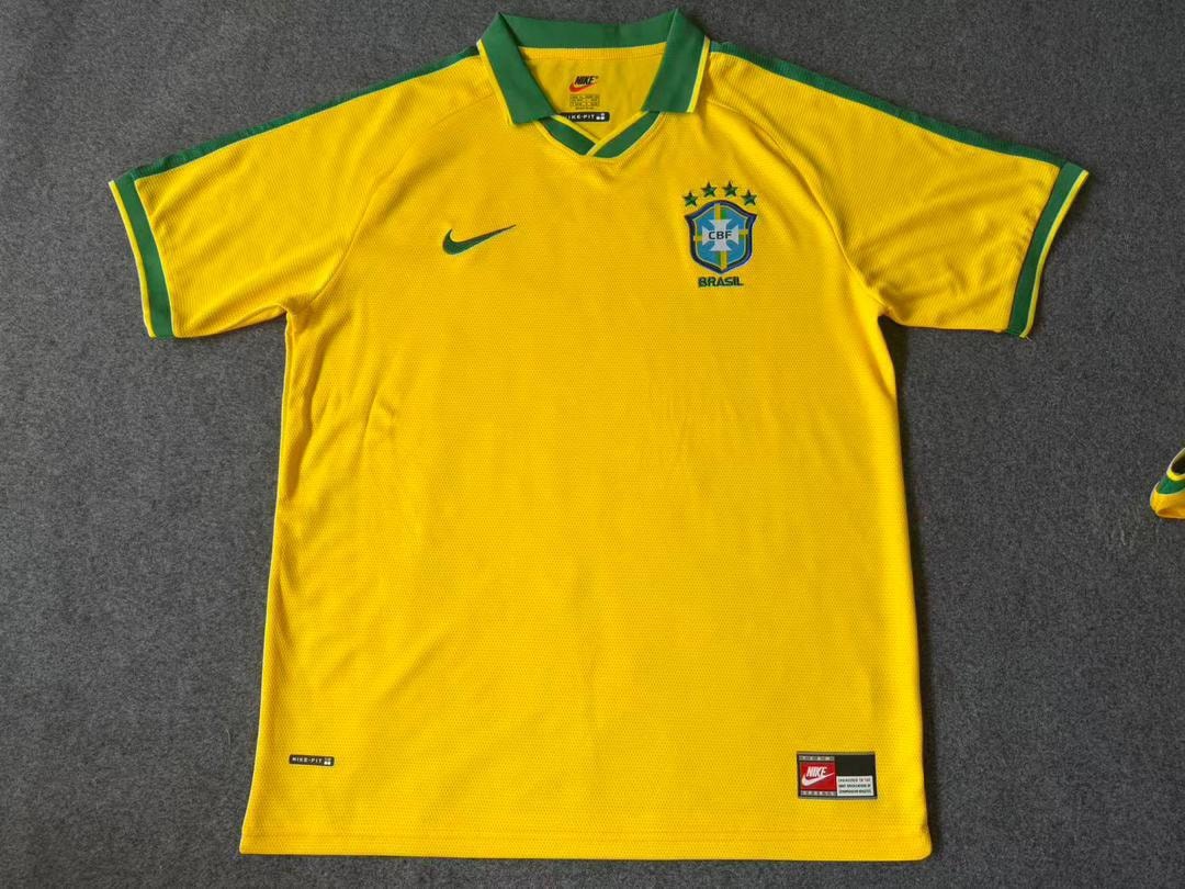 Yellow Brazil national team jersey laid flat on gray surface with Nike branding.