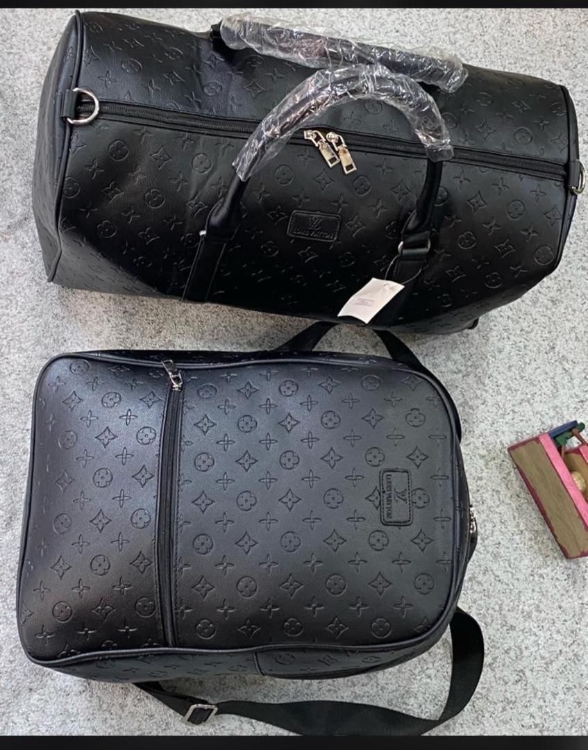 Black Louis Vuitton monogram duffel bag and matching messenger bag with embossed pattern on gray surface.
