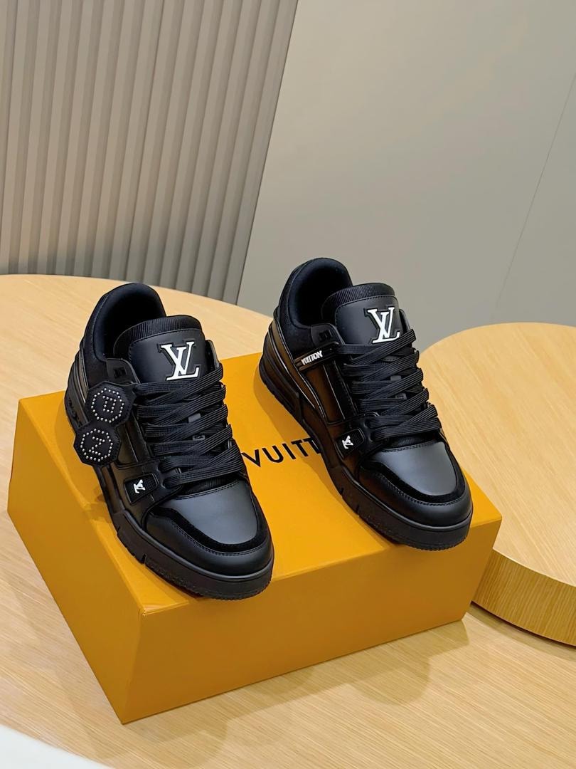 Black Louis Vuitton Trainer sneakers on yellow LV box.