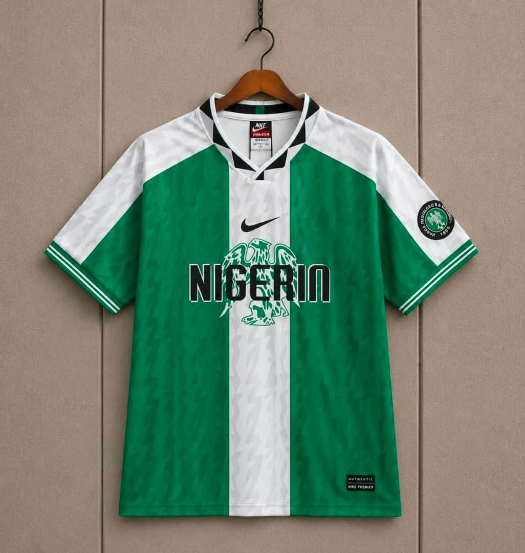 Green and white Nike Nigeria Super Eagles jersey hanging on wall.