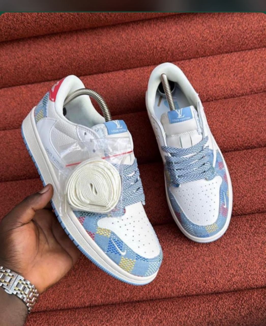 White Nike Air Force 1 with blue patterned LV design and tags.