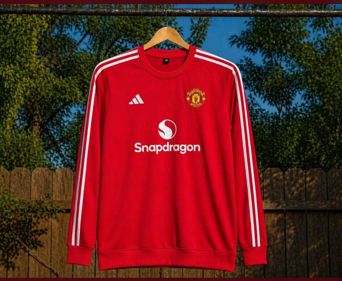 Red Manchester United long sleeve jersey with white stripes and Snapdragon sponsor.