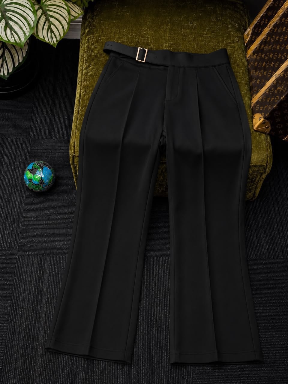Front view of black high-waisted flare trousers with belt.