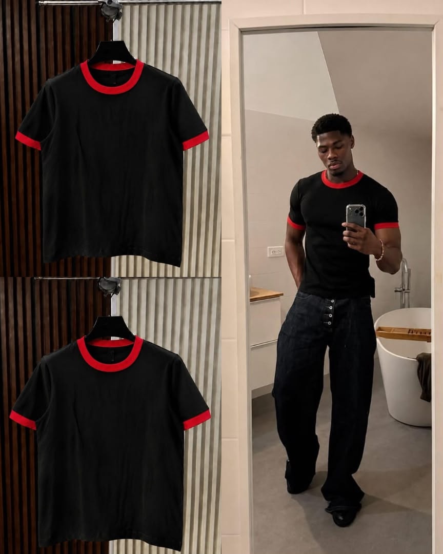Black t-shirt with red contrast trim on neck and cuffs, shown on hanger and model.