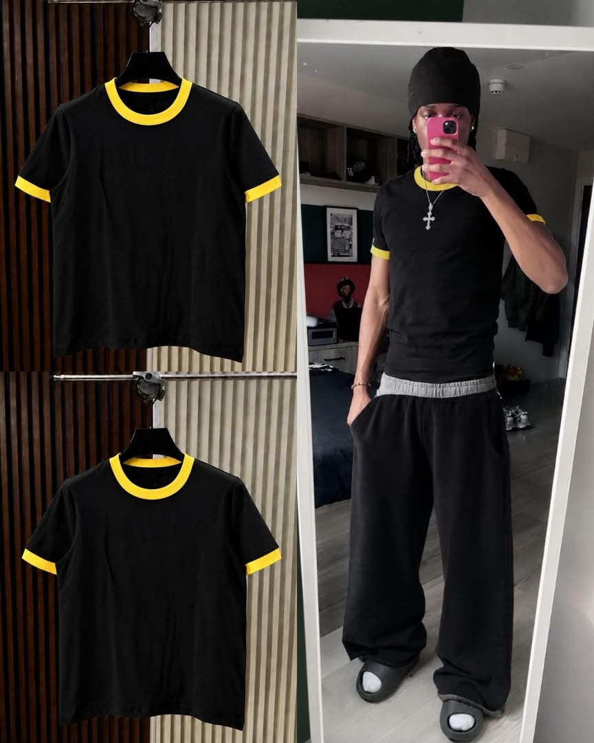 Black t-shirt with yellow contrast trim on neck and cuffs, shown on hanger and model.