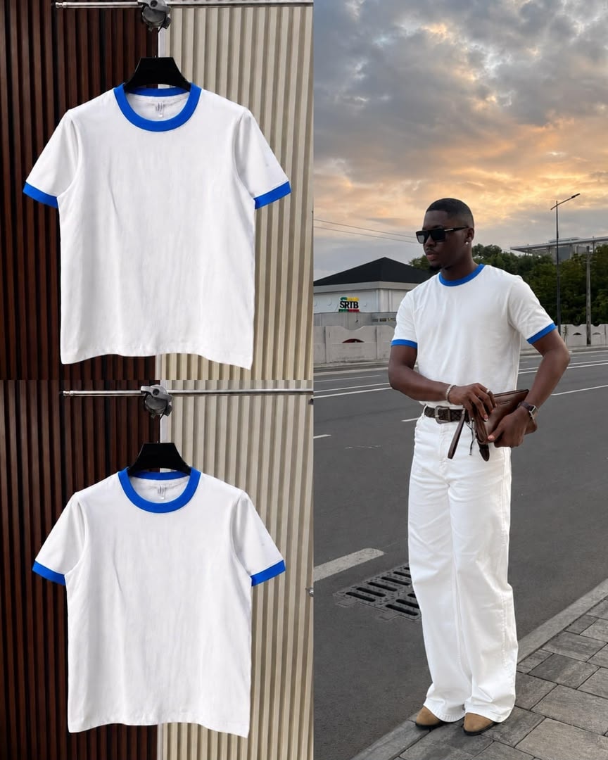 White t-shirt with blue contrast trim on neck and cuffs, shown on hanger and model.