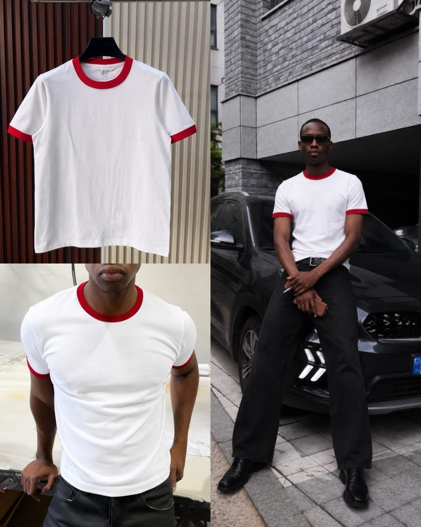 White t-shirt with red contrast trim on neck and cuffs, shown on hanger and model.