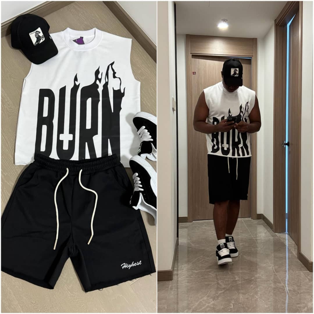 White sleeveless top with black BURN flame graphic, black shorts, cap and sneakers.